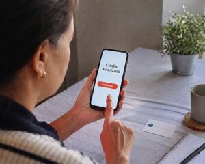 Persona verifica por otro canal un anuncio financiero sospechoso antes de compartir datos o realizar una transferencia.